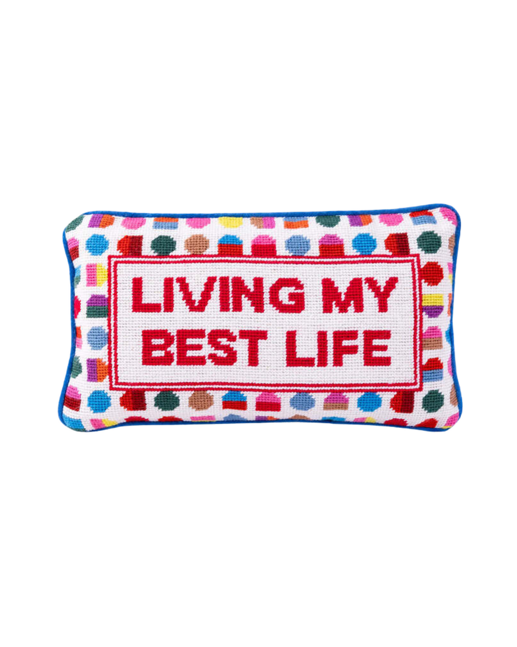 A vibrant hand-stitched needlepoint pillow with the text "LIVING MY BEST LIFE" in red, surrounded by colorful geometric patterns.