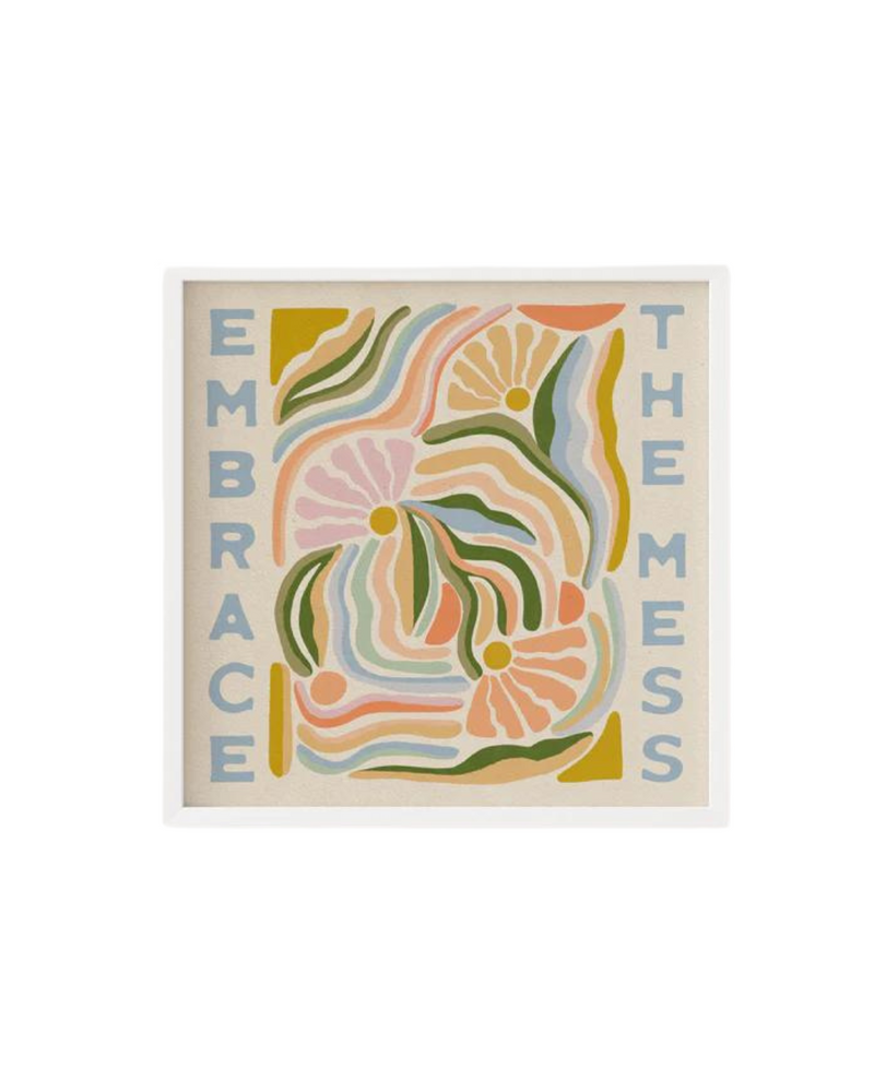  A framed print featuring the phrase "Embrace the Mess" in blue capital letters around a colorful abstract design with floral and wavy patterns in shades of pink, green, yellow, and orange. The print is set against a beige background.