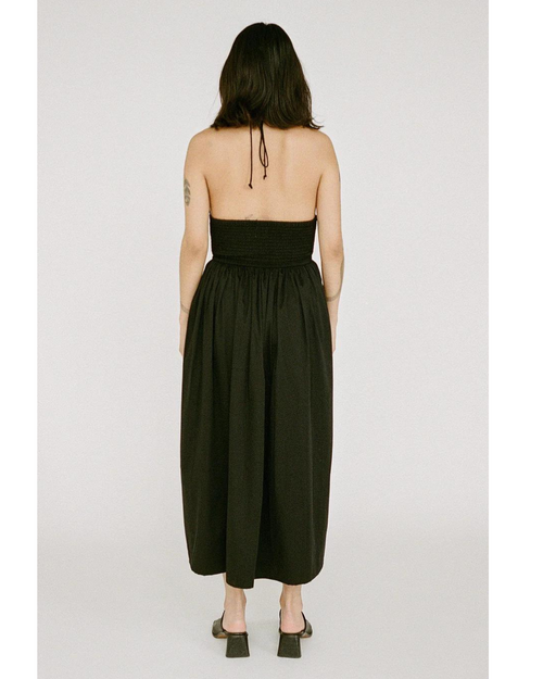 Back view of a women in the Halter Midi dress in black, with a delicate halter straps and intricate double elastic shirring.