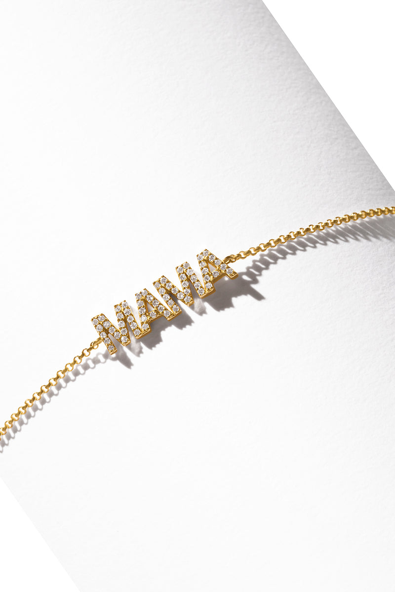 A 14k gold bracelet featuring a word-shaped charm that spells out Mama encrusted with diamonds. 