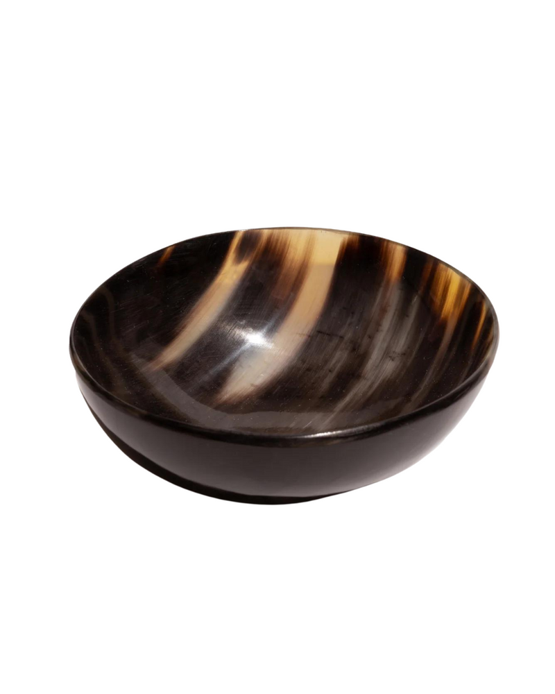 A round bowl made from real horn, showcasing a blend of dark and light natural hues, handcrafted by Creative Co Op.