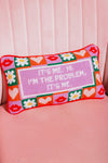 A pillow with the words "it's me, i'm the problem it's me" written on it, reflecting self-awareness and accountability on a pink sofa