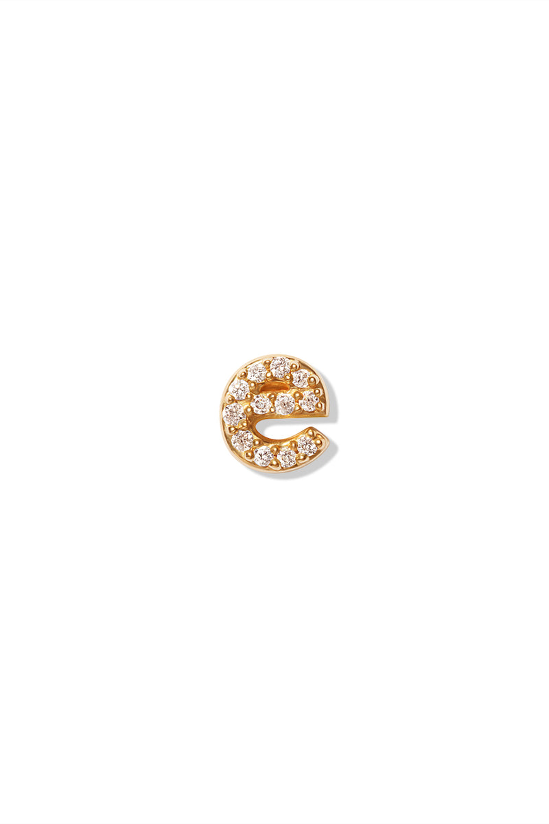 A small 14K yellow gold stud earring in the shape of the letter "e", encrusted with diamonds.